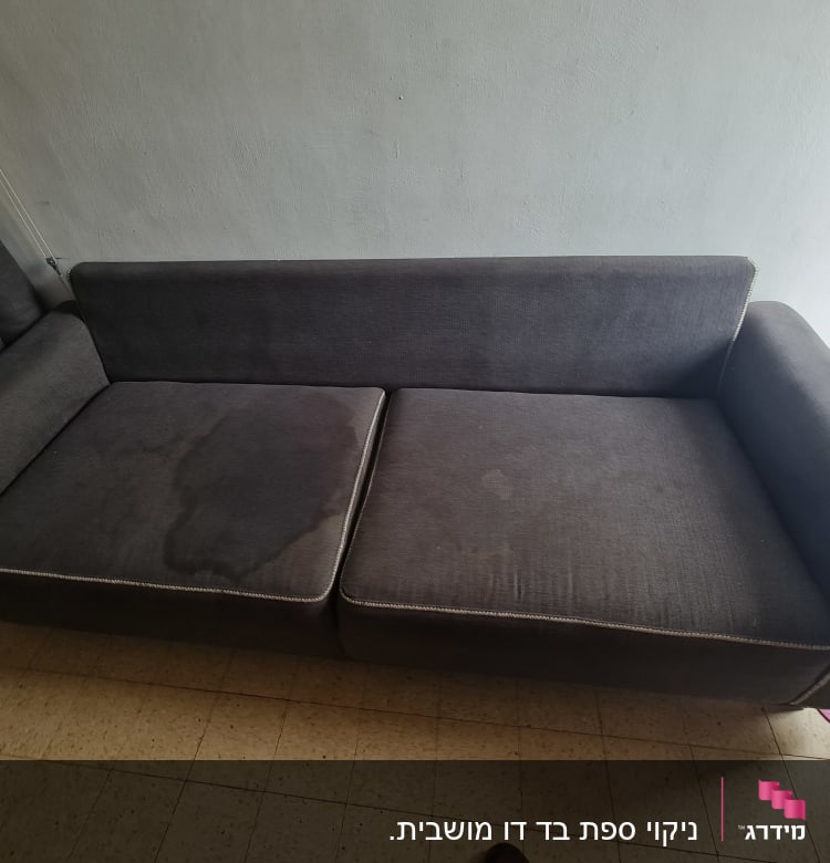 ספה אפורה עם כתמי רטיבות על המושב